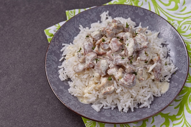 Stewed chicken gizzards in sour cream sauce with rice