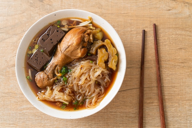 Tagliatelle di pollo in umido in ciotola di zuppa marrone - stile di cibo asiatico