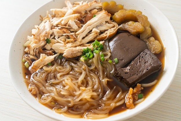 Tagliatelle di pollo in umido in ciotola di zuppa marrone - stile di cibo asiatico