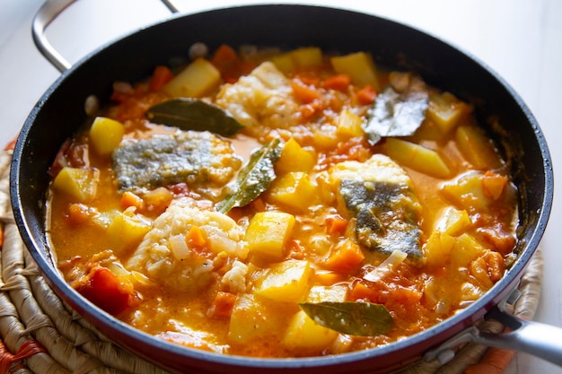 Photo stewed cod with potatoes and vegetables. traditional northern spanish recipe.