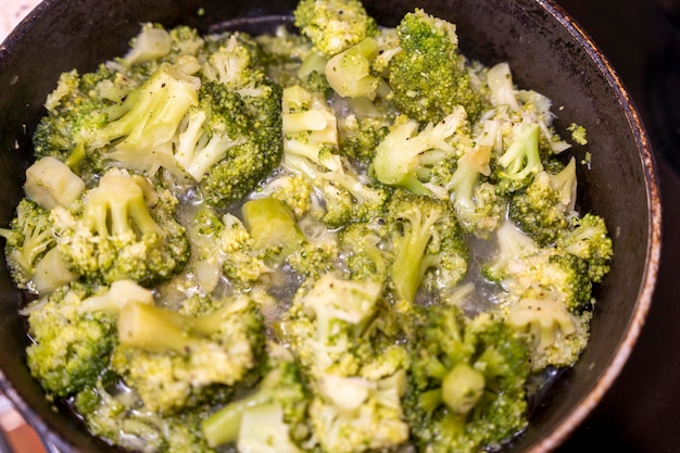 Foto cavolfiore fritto stufato in padella durante la cottura di una cena vegetariana vitamine e verdure biologiche alimentazione sana