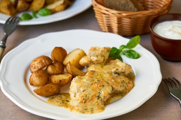 Stewed pork in creamy sauce with baked potatoes