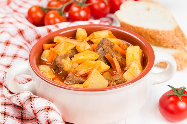 Stewed potatoes with meat carrots and tomatoes