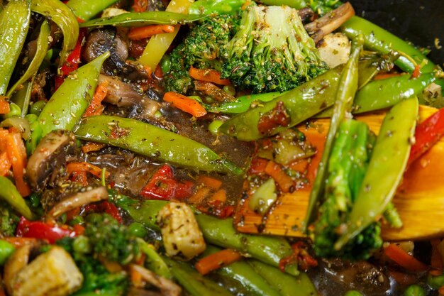 Stewed vegetables broccoli tomatoes and green peas with closeup