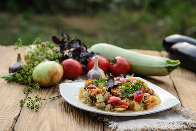 Stewed vegetables in a white bowl on wooden table