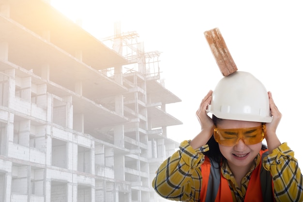 The stick block brick fell on the Asia engineer young woman head on the helmet worker