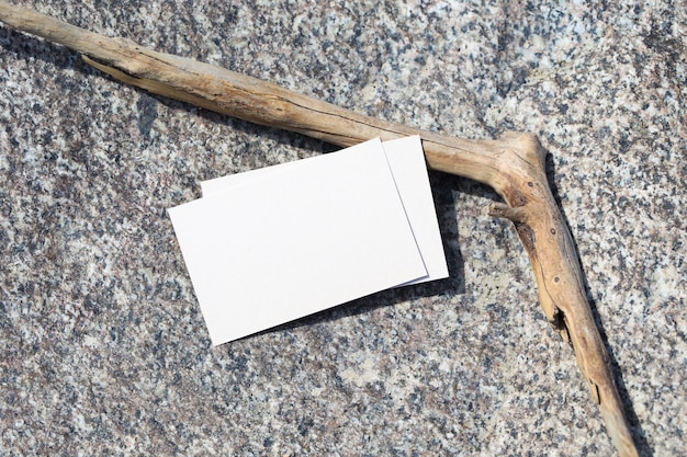 Photo a stick with a card on it next to a piece of wood.