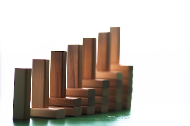 Stick wood block standing on stacked square wood blocks, abstract background in concept of winning, success, challenge, step to top position.