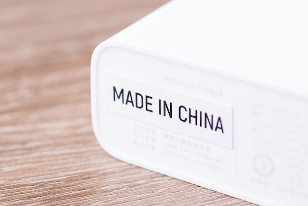 Adesivo con iscrizione made in china su dispositivo elettrico bianco primo piano globalizzazione e produzione di prodotti di massa nel concetto cinese