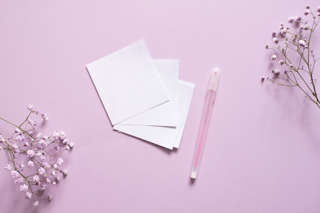 Stickers for writing with a pen on a purple background next to a white ribbon and white flowers