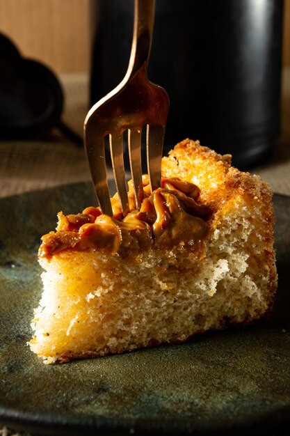 Sticking a fork on a slice of churros cake with dulce de leche a typical brazilian cake