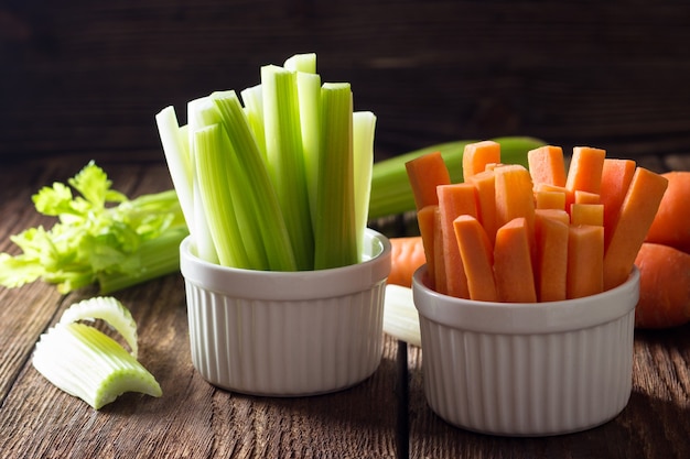 The sticks of carrots and celery on wooden table.