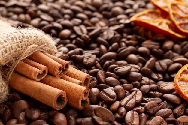 Sticks of fragrant cinnamon in a burlap pouch and dried orange pieces 