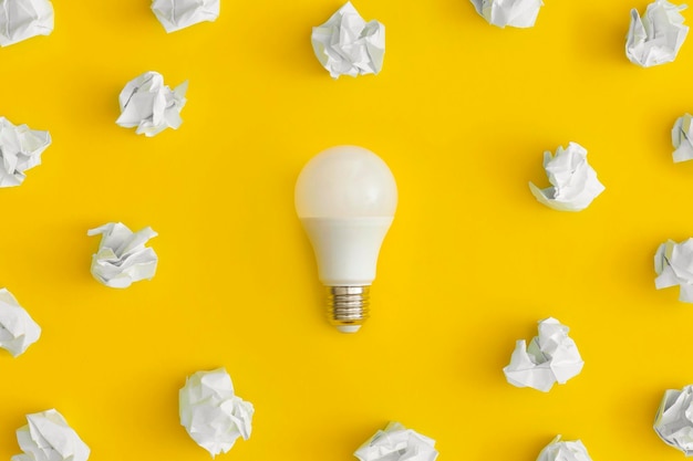 Sticky notes and light bulb on yellow background inspiration\
and creative idea concept