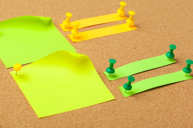 Sticky notes met pushpins en lege ruimte op kurk. School of bedrijfsconcept