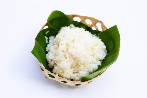 Sticky rice on banana leaf in bamboo basket on white background