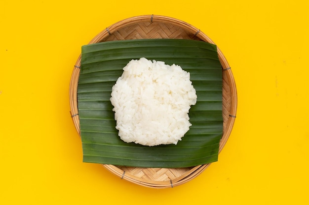 Sticky rice on banana leaf in bamboo plate