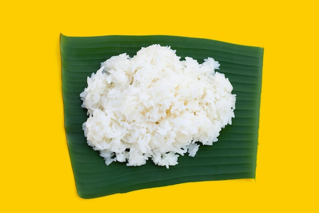 Sticky rice on banana leaf on yellow background