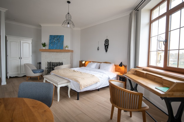 Stijl, binnenland. Stijlvolle lichte gezellige woonkamer met witte muren en open haard met modern interieur in nieuw huis