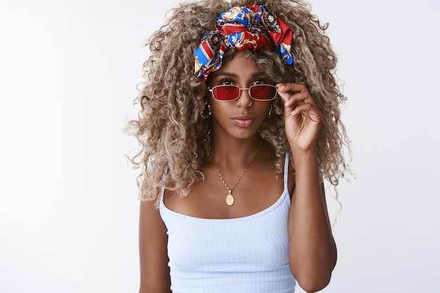 Stijl mode en vrouwen concept Aantrekkelijk brutaal en cool blonde hipster Afro-Amerikaanse vrouw met afro kapsel dragen rode trendy bril hoofdband opstijgen brillen kijken zelfverzekerd en serieus