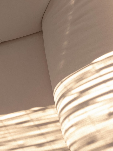 Foto stijlvol beige behang. banktextuur en zonschaduwen. minimalistische modedetails