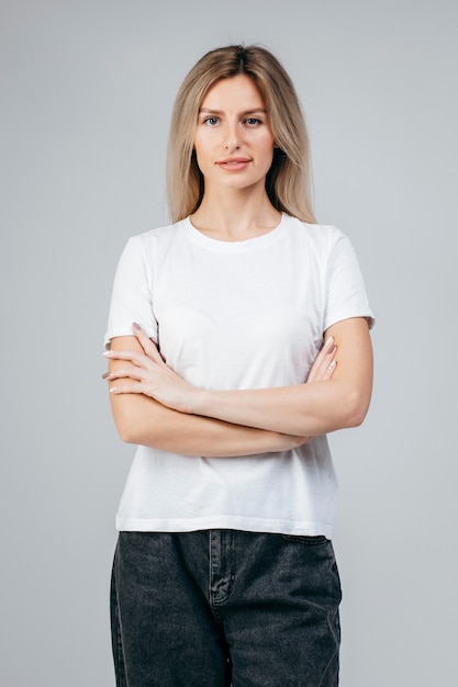 Stijlvol blond meisje dat het witte t-shirt poseren draagt