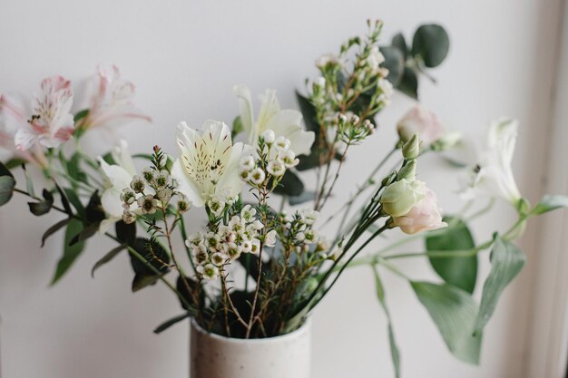 Stijlvol boeket in keramische vaas bij raam humeurig beeld Mooie verse bloemen close-up