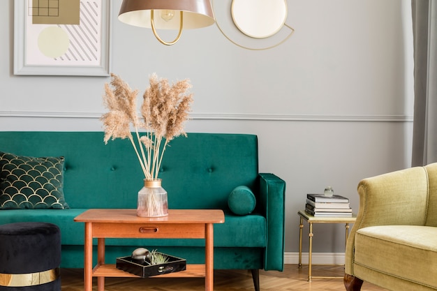 Stijlvol en luxe woonkamerinterieur met elegante groene fluwelen fauteuil, bank, salontafel, marmeren standaards, designlampen, kunstschilderijen en chique accessoires in woondecoratie.