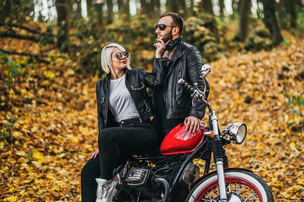 Stijlvol fietsend stel met een rode motorfiets