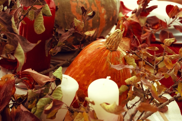 Stijlvol herfstdecoratietafeltje met pompoen en gedroogde takken