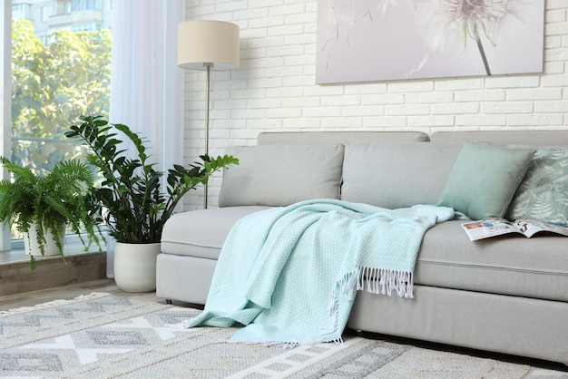Stijlvol interieur van de woonkamer met een comfortabele bank bij een witte bakstenen muur