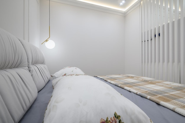 Stijlvol interieur van grijze en witte slaapkamer met comfortabel bed