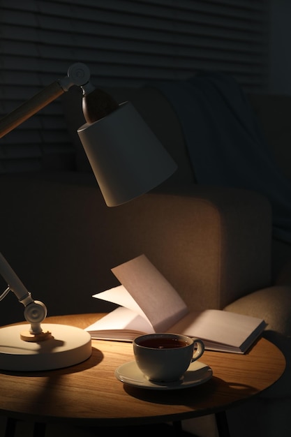 Stijlvol lampboek en een kopje thee op een zijtafel binnen