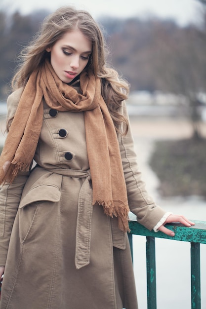 Stijlvol model met een bruine jas buiten in het park