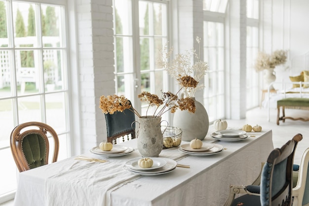 Stijlvol modern interieur van de eetkamer in de herfstkeuken met vintage stoelen