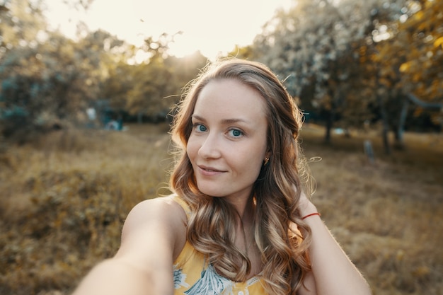 Stijlvol modern meisje dat een selfie neemt in het park.