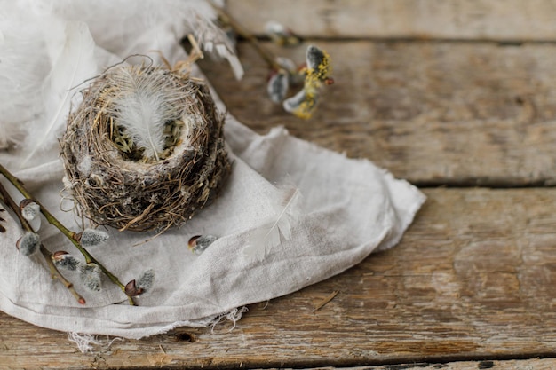 Stijlvol Pasen rustiek stilleven Nest met veren wilgentakken linnen doek op oud hout