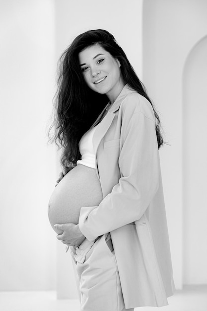 Stijlvol zwanger brunette meisje met broekpak