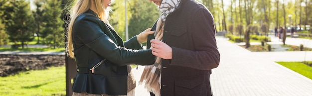 Stijlvol zwangerschapsconcept - close-up van het portret van een paar hipsters, man en vrouw in trendy kleding die in het stadspark lopen