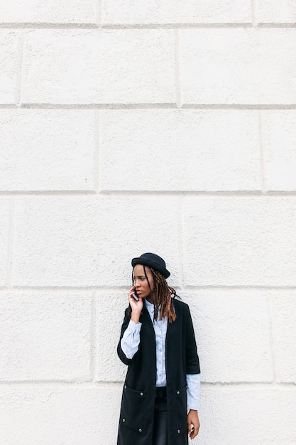 Stijlvolle African American meisje op witte achtergrond. Moderne sociale communicatie, zwarte mannequin buitenshuis, schoonheidsconcept