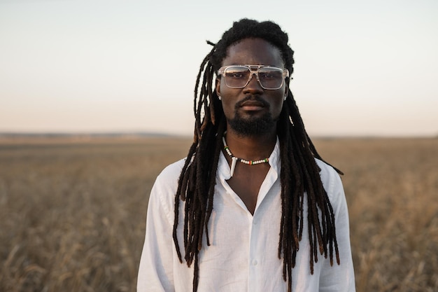 stijlvolle Afrikaanse man in een bril in het veld in de zomer