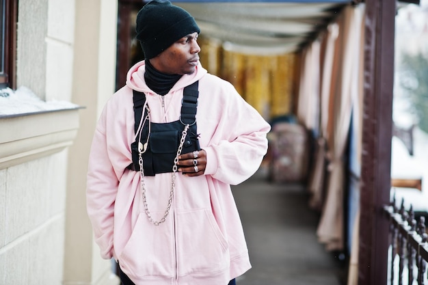 Stijlvolle Afro-Amerikaanse man in stedelijke stijl in roze hoodie poseerde