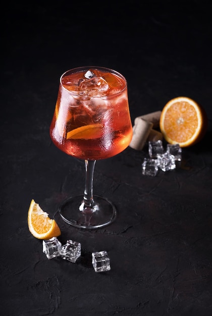 Stijlvolle alcoholische aperol spritz trendy cocktail met sinaasappelschijfje op zwarte achtergrond Klassieke Italiaanse aperol