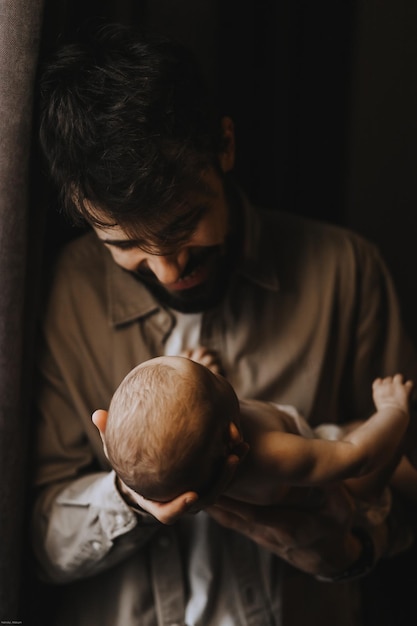 Stijlvolle blanke bebaarde vader met een pasgeboren baby op de schouder Alleenstaande vader gezinsleven concept