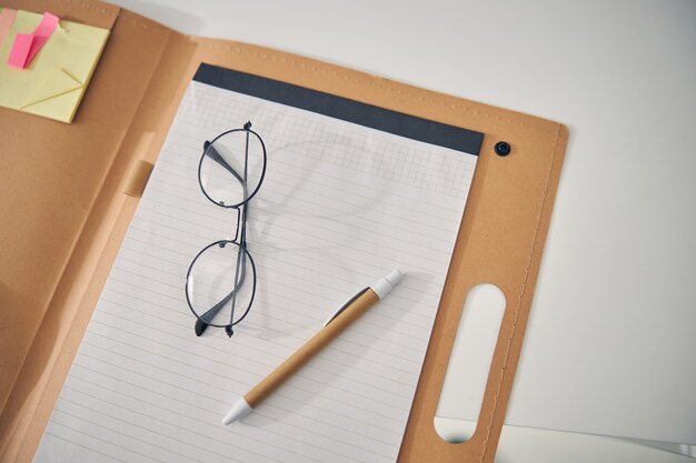 Stijlvolle bril op notitieboekje, pen is klaar om aantekeningen te maken tijdens overleg