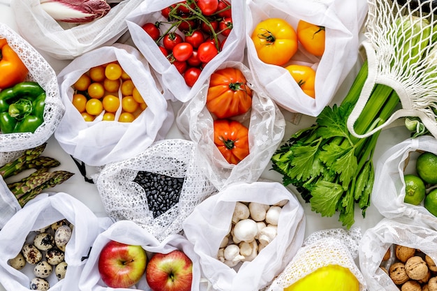 Stijlvolle compositie op de marmeren tafel met nul afvalzakken, noten, zaden, eieren, biologische groenten en eco fruit