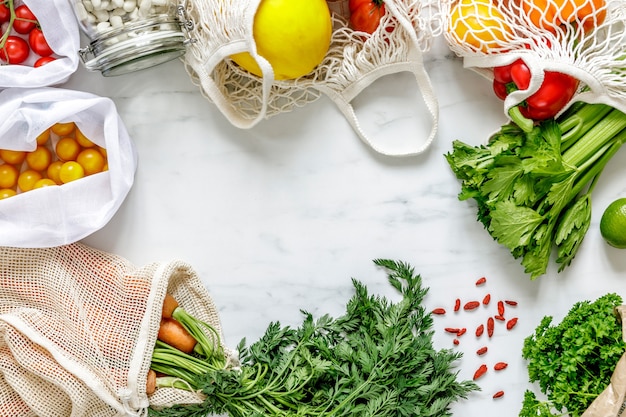 Stijlvolle compositie op de marmeren tafel met nul afvalzakken, noten, zaden, eieren, biologische groenten en eco fruit