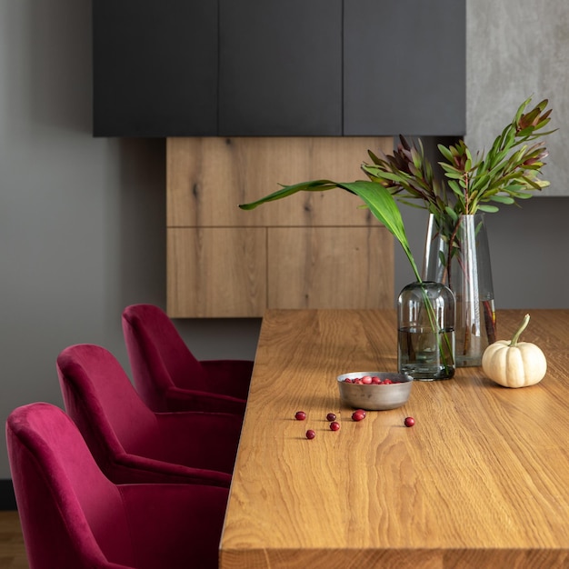 Stijlvolle compositie van elegant eetkamerinterieur met fluwelen stoelen design houten tafellampen schoorsteen en mooie persoonlijke accessoires Modern interieur