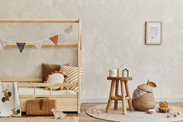 Stijlvolle compositie van gezellig scandinavisch kinderkamerinterieur met houten bed, speelgoed en hangende decoraties. creatieve muur. ruimte kopiëren. sjabloon.