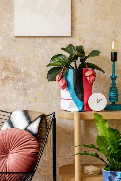 Foto stijlvolle compositie van woonkamer interieur met fotolijst, houten console, design fauteuil, planten in hipster pot, decoratie, boek, tafellamp en persoonlijke accessoires.